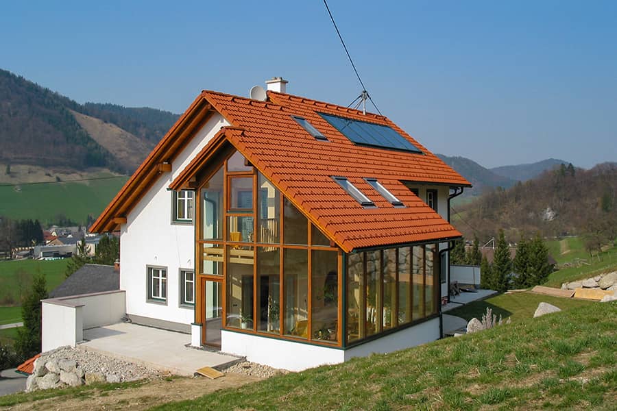 Einfamilienhaus-Satteldach-rot-Wintergarten-Holz-Hanglage-900x600