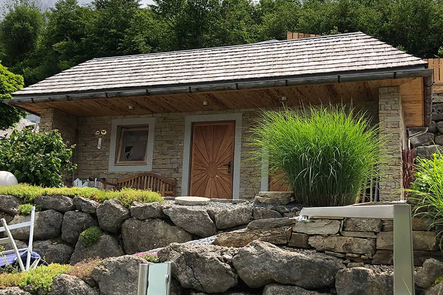Gartenanlage-Gartenhaus-Steinfassade-urig-rustikal-Steinschlichtung-Schindeldeckung-1-900x600