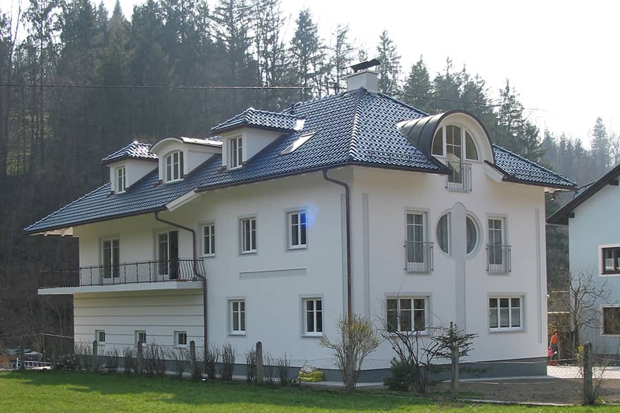 Mehrfamilienhaus-Walmdach-gobiert-Fassade-weiss-Faschen-grau-Gauben-900x600